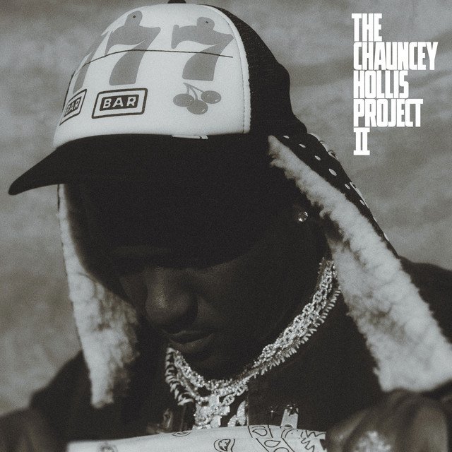 The Chauncey Hollis Project II cover: a black and white photo of Hit-Boy in a trucker hat with 777 and a jacket with a fur collar